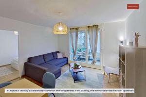 un soggiorno con un divano blu e un tavolo di Living Cozy in Bern a Berna 1 altra foto