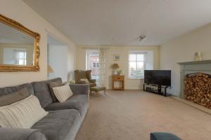 a living room with a couch and a television at Cozy 3BR escape near Edinburgh centre in Edinburgh