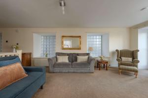 a living room with a couch and a chair at Cozy 3BR escape near Edinburgh centre in Edinburgh