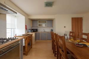 a large kitchen with a wooden table and chairs at Cozy 3BR escape near Edinburgh centre in Edinburgh