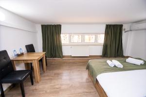 a bedroom with a bed and a desk and a table at MBM Hotel in Yerevan