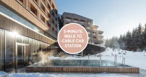 a building with a sign that reads walk to cake car station at Falkensteiner Hotel Schladming in Schladming