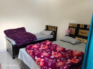 two beds in a room with purple blankets on them at Himadri Homestay Sari Devriyatal in Sari +3 photos