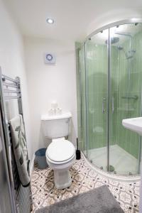 a bathroom with a toilet and a glass shower at Stather Cottage in Burton upon Stather +34 photos