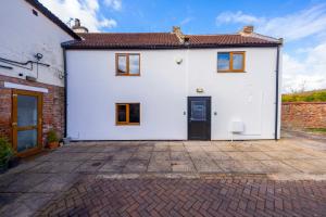 a white house with a brick driveway at Stather Cottage in Burton upon Stather