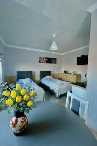 肯普诺Apartament Adabet的一间设有一张桌子的房间,花瓶是黄色的