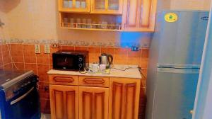 a kitchen with a counter with a microwave and a refrigerator at ليالي اكتوبر in 6th Of October