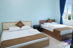 two beds in a room with blue walls at Chely Hotel in Mù Cang Chải