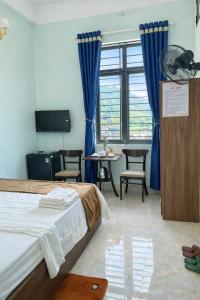 ein Hotelzimmer mit Bett, Tisch und Stühlen in der Unterkunft Chely Hotel in Mù Cang Chải