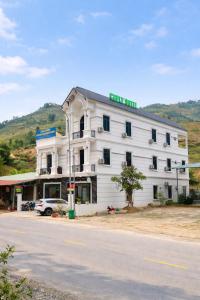 ein weißes Gebäude am Straßenrand in der Unterkunft Chely Hotel in Mù Cang Chải + 8 Fotos