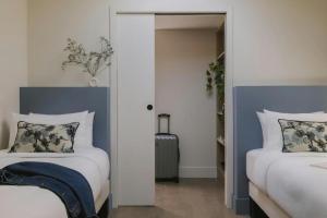 a bedroom with two beds and a door with a suitcase at Crisol Mozart in Nice +35 photos