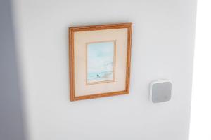 a picture frame hanging on a wall next to a lightswitch at Shore Cottage - Lower Largo in Lower Largo