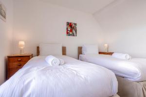 two beds with white sheets in a room at Shore Cottage - Lower Largo in Lower Largo