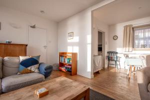 a living room with a couch and a table at Shore Cottage - Lower Largo in Lower Largo