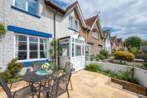 a patio with a table and chairs in front of a house at 3 Bed in Beer oc-jb9wes in Beer