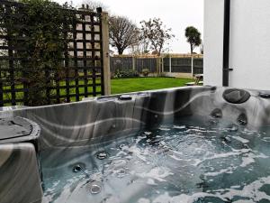 una vasca idromassaggio in un cortile con recinzione di 3 Bed in Brynteg oc-d33659 a Llanallgo