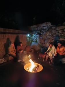 eine Gruppe von Menschen, die nachts um eine Feuerstelle herum sitzen in der Unterkunft Apartamento rural Sé de un lugar in El Torno