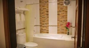 a bathroom with a tub and a toilet and a sink at KTC HOTEL in Bidur