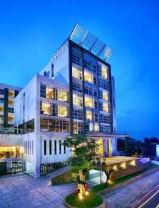 een hoog gebouw met lichten ervoor bij Apartemen Bumi in Solo