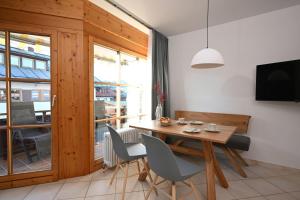 a dining room with a wooden table and chairs at Ferienwohnung Nau in Oberstdorf