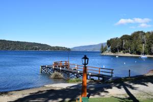 un poste de luz junto a un muelle sobre un cuerpo de agua en Cabaña con costa de lago en San Carlos de Bariloche