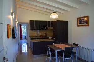 una cucina con tavolo e sedie e una sala da pranzo di Cabaña con costa de lago a San Carlos de Bariloche