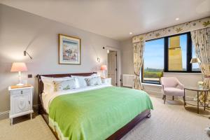 a bedroom with a green bed and a large window at Badgerwood in Winchcombe