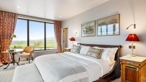 a bedroom with a bed and a desk and a window at Badgerwood in Winchcombe