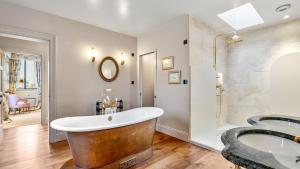 a bathroom with a tub and a sink at Badgerwood in Winchcombe