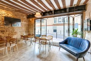 a dining room with a table and chairs and windows at Hôtel Marie in Paris