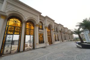 a large building with large windows in a street at Hotel Maharaja Palace Rohtak in Kahrāwar