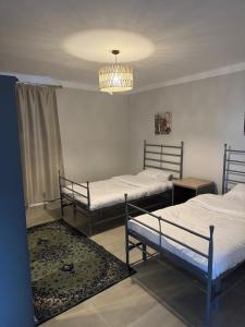 a room with three beds and a chandelier at Apartment in Elshatby in Alexandria