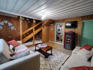 a living room with a couch and a table and a tv at Casuta Mariei, Borsa,Maramures in Borşa