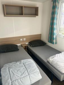 two beds in a small room with a window at GRS Mobil Home in Onzain +21 photos