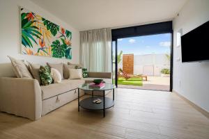 een woonkamer met een bank en een tafel bij Royal Blue San Agustin in San Bartolomé