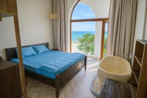 a bedroom with a bed and a view of the ocean at HiDra Homestay in An Tịnh