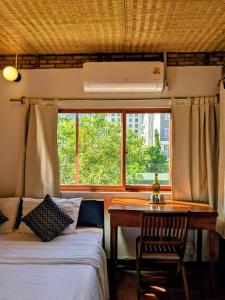 a bedroom with two beds and a desk and a window at YK Art House in Phnom Penh