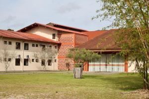un edificio arancione e bianco con un cortile verde di Pousada Divino Oleiro - Gov. Celso Ramos a Governador Celso Ramos