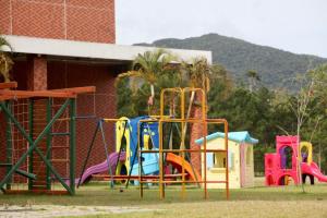 un gruppo di attrezzature per il parco giochi di fronte a un edificio di Pousada Divino Oleiro - Gov. Celso Ramos a Governador Celso Ramos