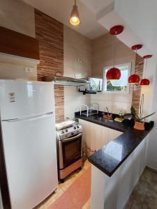 eine Küche mit einem weißen Kühlschrank und einem Herd in der Unterkunft Casa de Praia Maresias in Maresias