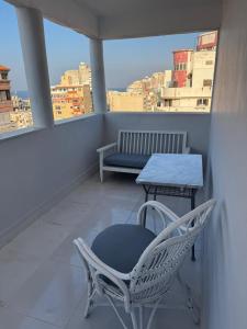 a chair and a table on a balcony with a view at Apartment in Elshatby in Alexandria