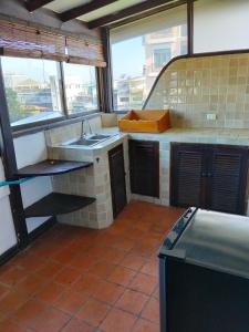 een keuken met een spoelbak en een aanrechtblad bij The Loft Sihom in Vientiane