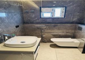 a bathroom with a white toilet and a sink at Hotel Royal Plaza in Phulabāni