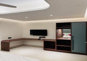 a room with a bed and a tv and a desk at Hotel Royal Plaza in Phulabāni