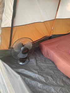 een ventilator die op de vloer van een tent staat bij Kohkood camp in Ban Khlong Mat