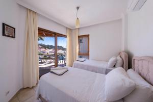 ein Schlafzimmer mit zwei Betten und einem Balkon in der Unterkunft Villa Tara in Kaş + 38 Fotos