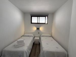twee bedden in een kleine kamer met een raam bij Riviera Paradise in Las Palmas de Gran Canaria +18 foto's