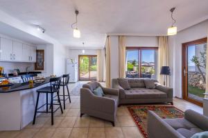 eine Küche und ein Wohnzimmer mit Sofa und Tisch in der Unterkunft Villa Tara in Kaş