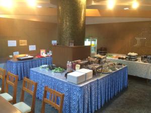 una linea a buffet con tavoli blu con sopra cibo di Hotel Crown Hills Tokuyama a Shunan