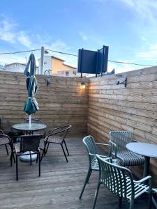 a patio with tables and chairs and a tv on a fence at GreeneStay Sindang DDP Seoul in Seoul